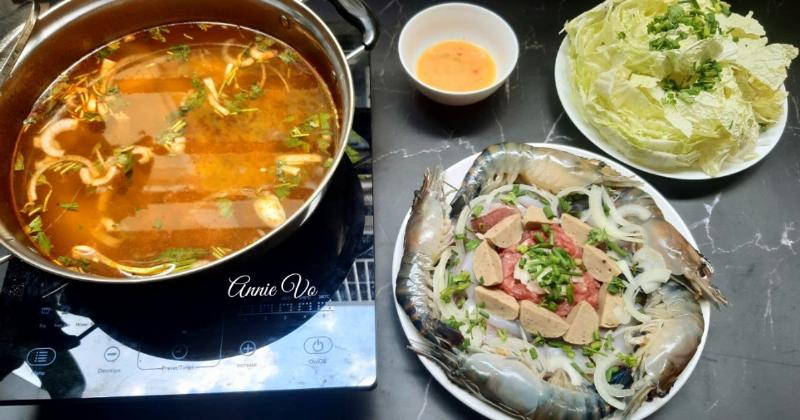 Gia đình quây quần thưởng thức nồi lẩu tôm càng nóng hổi trên bàn ăn